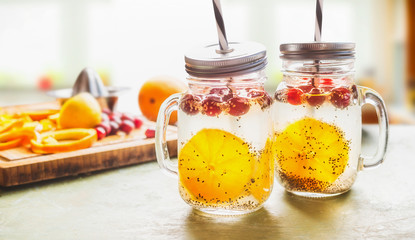 Breakfast Chia seeds water in Mason jars on table with orange slices and cranberries. Natural detox energy drink.  Proper nutrition, healthy supplements. Transparent drink. Superfood and dieting
