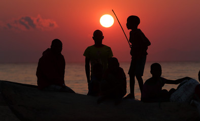 Silhouettes of fishermen at sunrise Chitimba, Lake Malawi, Malawi. 