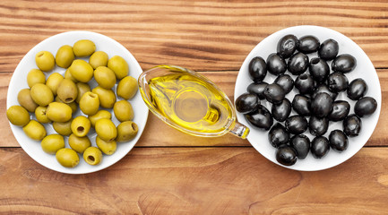 Gravy boat with olive oil and saucers with olives on the table. Top view.
