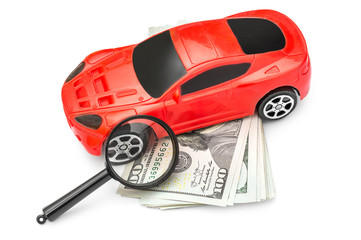  Magnifying glass with red car toy and money on white.