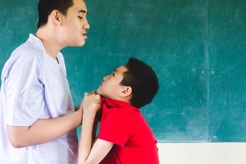 Wrangling boys being bullied, pull collar, ready to hit