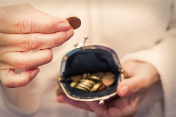 woman inserting coins in her purse