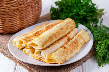 Lavash rolls with cheese on a white plate