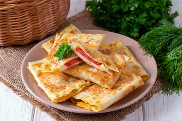 Lavash envelopes with cheese and tomatoes on a plate