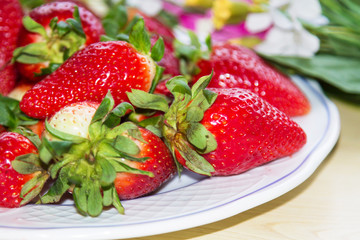 Fresh organic strawberries. Plate with juicy strawberry pieces, sliced fruit