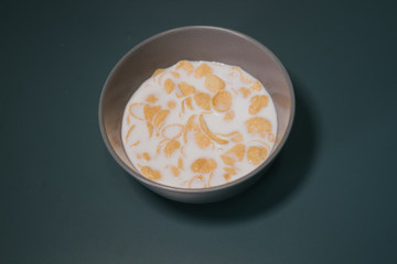 Cornflake cereal in the bowl with full cream milk.