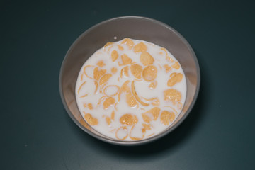 Cornflake cereal in the bowl with full cream milk.