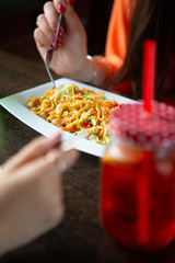 Girl eating asian noodles in a restaurant