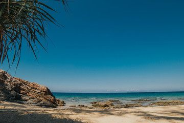 Fototapeta na wymiar Beautiful tropical island beach scenery with palm trees and nature rock formation.