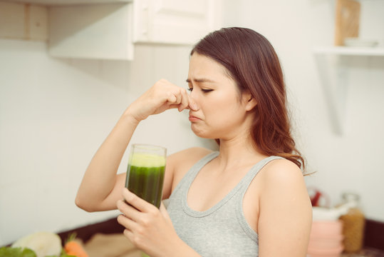 Woman Drinking Disgusting Green Smoothie, Closing Nose, Bad Smell And Taste