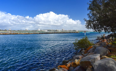 Mooloolaba Marina on Mooloolah River on a sunny but cloudy day. Rock wall along Mooloolah river (Sunshine Coast, Queensland, Australia).