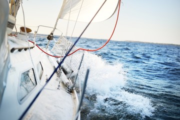 Panele Szklane Podświetlane  Biały jacht pływający w pogodny, słoneczny dzień. Widok z pokładu na dziób, maszt i żagle. Finlandia