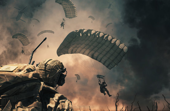 Military helicopter and forces between fire and smoke in destroyed city and soldiers are in flight with a parachute to reach battlefield/A soldier looks at them.