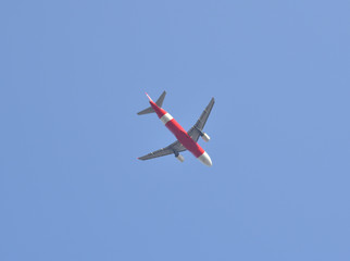 Airplane flying away to the blue sky