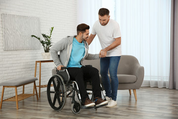 Fototapeta na wymiar Volunteer helping man in wheelchair at home