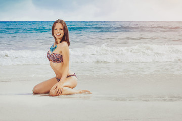 Fototapeta na wymiar Attractive girl on the beach is happy