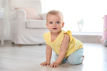 Cute baby girl on floor in room