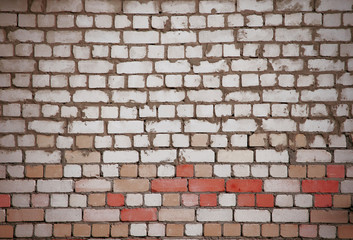 Wall of white and red bricks with uneven old masonry