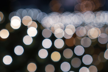 Abstract white yellow bokeh lights on road street in city night light background, decoration in soft for greeting card backdrop with glitter sparkle blurred circles
