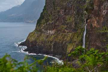 Beautiful view of a waterfall near the blue atlantic ocean and nice sky in Madeira