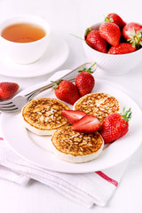 ThreeTasty Homemade Cottage Cheese Pancakes with Strawberries on White Plate Tasty Healthy Diey Breakfast Breakfast Concept Vertical