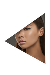 Cropped side geometric portrait of Asian girl with black flicks. The lady with dark hair is wearing stud earrings with black marbled insertion, looking at camera behind triangle-shaped foreground.