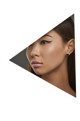 Cropped side geometric portrait of lady with black flicks. The woman with dark hair is wearing square-shaped stud earrings with black marbled insert, looking to the side behind triangle foreground.