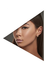 Cropped side geometric portrait of Asian woman with black flicks, looking at camera behind triangle foreground. The girl with dark hair is wearing golden stud earring, with faceted diamond enclosed.