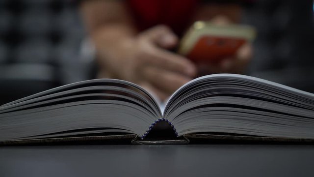 Reading old textbook in university library, read book or relaxing in vintage black background. Reading is complex cognitive process of decoding symbols to derive meaning communication information.