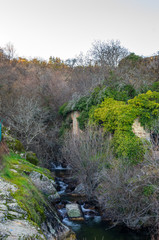 River stream flowing between the rocks next to the ruins of an old mill