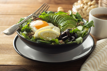 Healthy food. Eggs, quinoa, avocado, green salad, black olives. Wooden table. diet, lose weight.