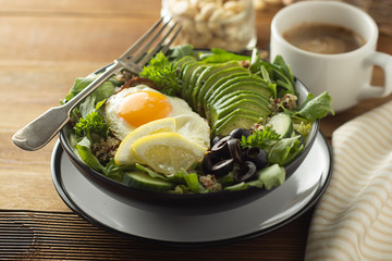 Healthy food. Eggs, quinoa, avocado, green salad, black olives. Wooden table. diet, lose weight.