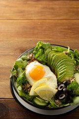 Healthy food. Eggs, quinoa, avocado, green salad, black olives. Wooden table. diet, lose weight.