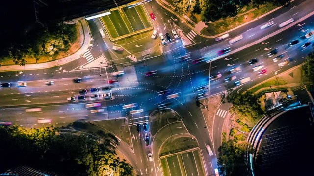 Aerial overhead hyperlapse of traffic at a busy intersection at night