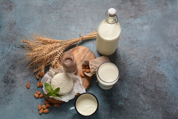 Almond milk in glass bottles with almond nuts on background. Vegan diary concept. Shavuot jewish holiday food concept - dairy products and wheat , copy space