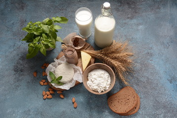 Almond milk in glass bottles with almond nuts on background. Vegan diary concept. Shavuot jewish holiday food concept - dairy products and wheat , copy space