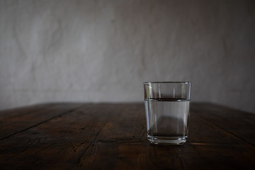 Einzelnes Wasserglas auf einem Holztisch