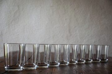 Nahaufnahme einer Reihe von leeren Gläsern auf einem Holztisch (Horizontal)