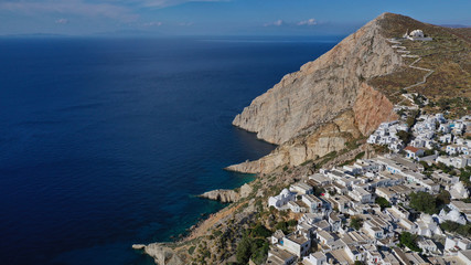 Fototapeta na wymiar Aerial drone photo of picturesque main village (chora) of Folegandros island featuring uphill church of Panagia (Virgin Mary) built on top of steep hill overlooking the Aegean sea, Cyclades, Greece