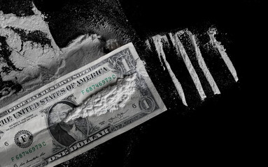 One dollar and cocaine lines isolated on black background 