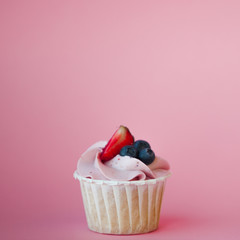 Sweet dessert on pink background, copy space. Cupcake with cream, beautiful and delicious.
