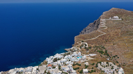Naklejka premium Aerial drone photo of iconic and picturesque main village (chora) of Folegandros island featuring castle and built on top of steep hill overlooking the Aegean blue sea, Cyclades, Greece