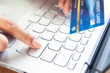 Woman hand holding plastic credit card and push enter button. Business and e-payment concept.