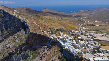 Aerial drone photo of iconic and picturesque main village (chora) of Folegandros island featuring castle and built on top of steep hill overlooking the Aegean blue sea, Cyclades, Greece