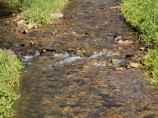 Stream running over broown roack and pebbles