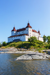 White beautiful castle on a hill by a lake