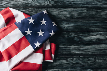 folded flag of united states of america on grey wooden surface, memorial day concept