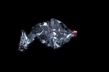 Empty plastic bottle isolated on black background. Nature protection concept.