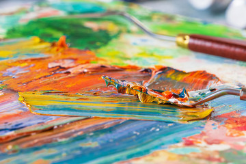 Bright, juicy, multi-colored abstraction of their mixing of oil paints on a palette close-up.