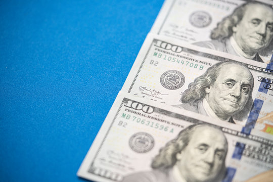 US one hundred dollars bills money on blue background